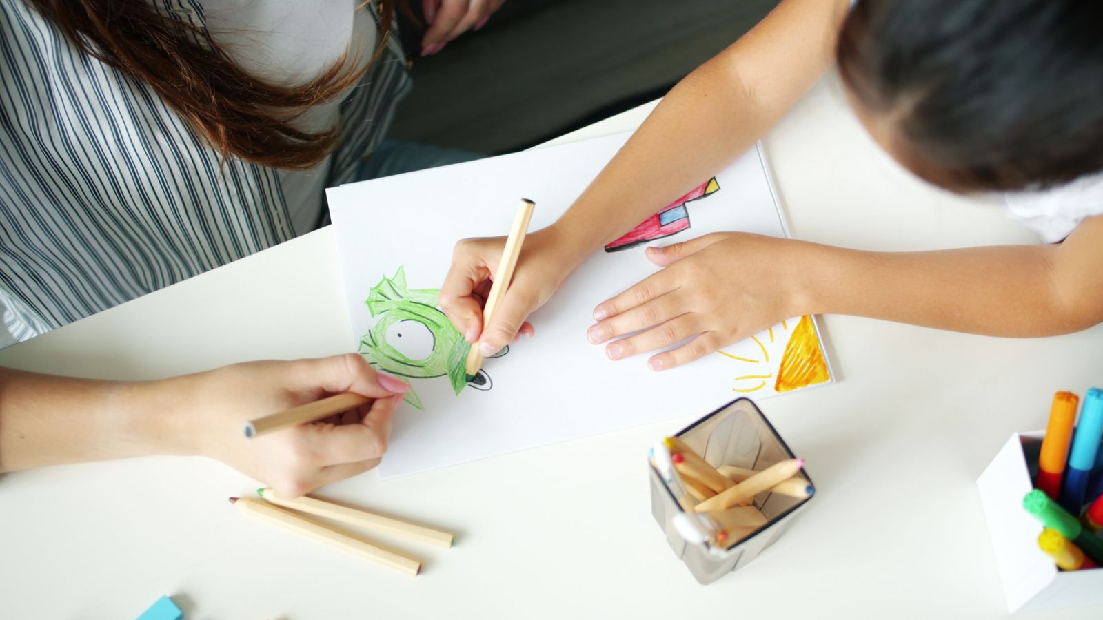 An adult and child drawing together during a learning activity